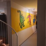 Muurschildering Amsterdam in stijl van Keith Haring gang bij ingang