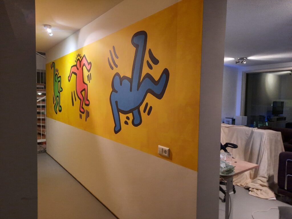 Muurschildering Amsterdam Keith Haring gang bij woonkamer